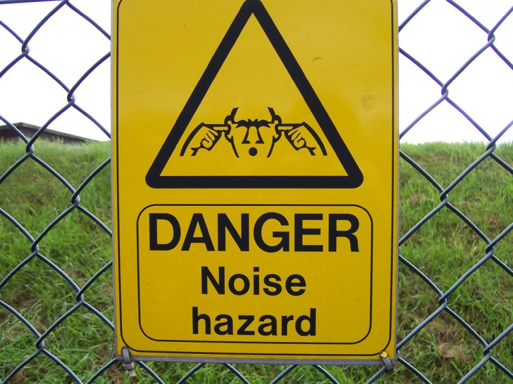 Danger noise hazard sign with an image of someone plugging their ears