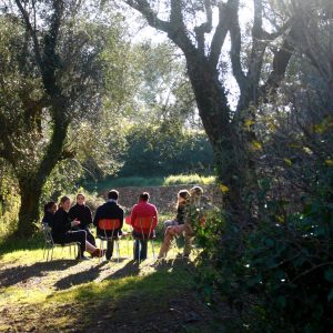 Photo of a group of people sitting in nature.