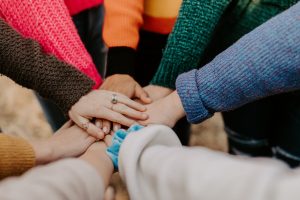 People with their hands together.