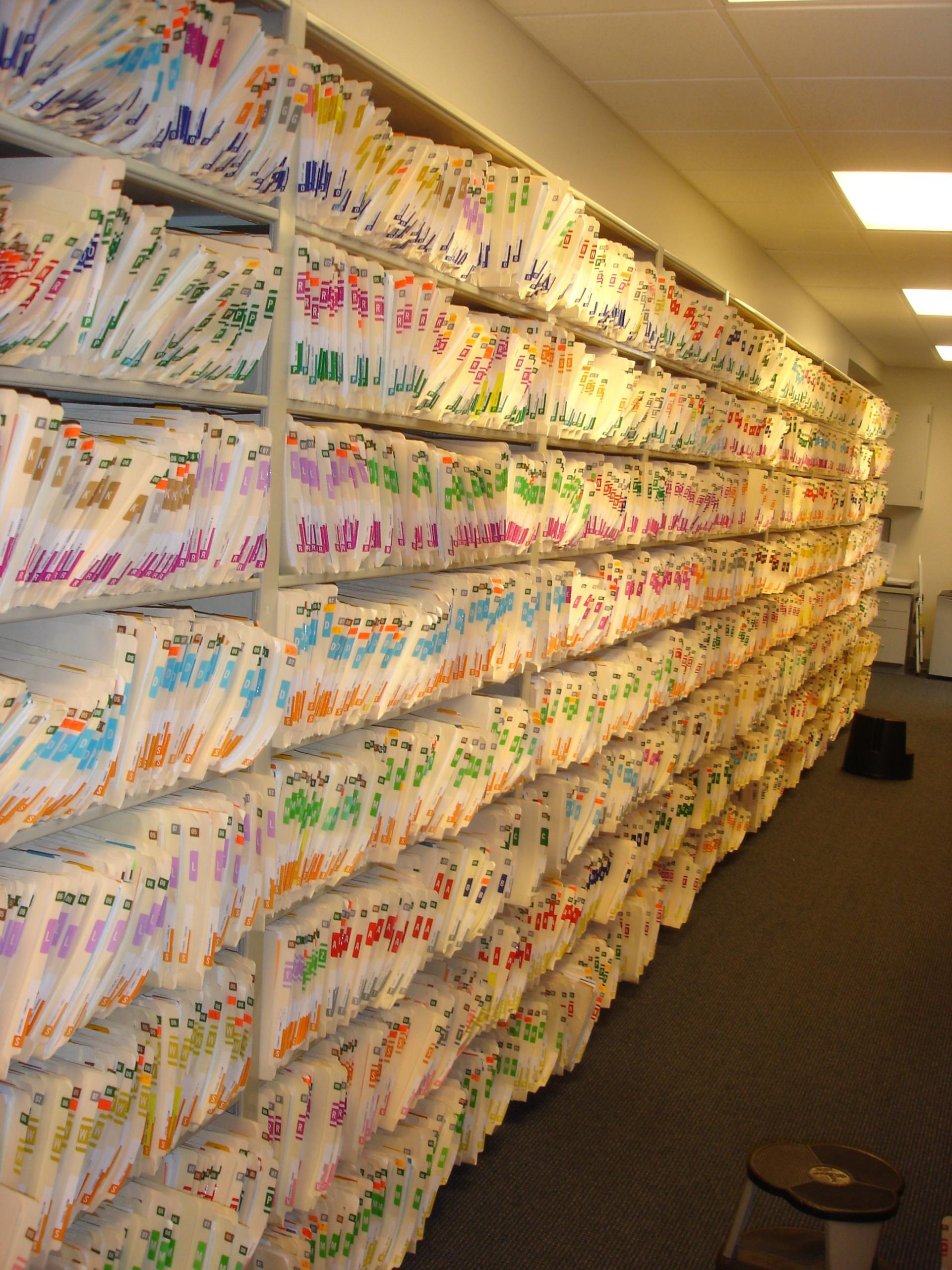 Photo of a wall of shelves filled with paper medical records