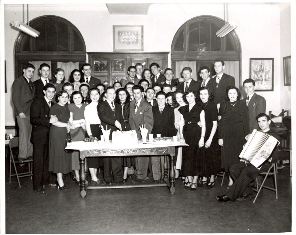 Rassemblement du Hakoah New Canadians Club pour survivants de l'Holocauste nouvellement arrivés au YMHA à Montréal, Canada. Mitchell Seidenfeld, un survivant tchécoslovaque, coupe le gâteau.