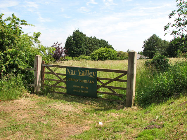 photo showing wooden gate with sign for Nar Valley Green Burials before a field of green grass