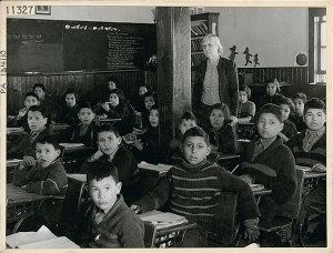 Cree students and teacher in class at All Saints Indian Residential School, (Anglican Mission School), Lac La Ronge, Saskatchewan, March 1945.