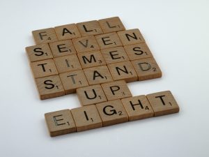Scrabble tiles that spell out the statement, "Fall seven times, stand up eight."