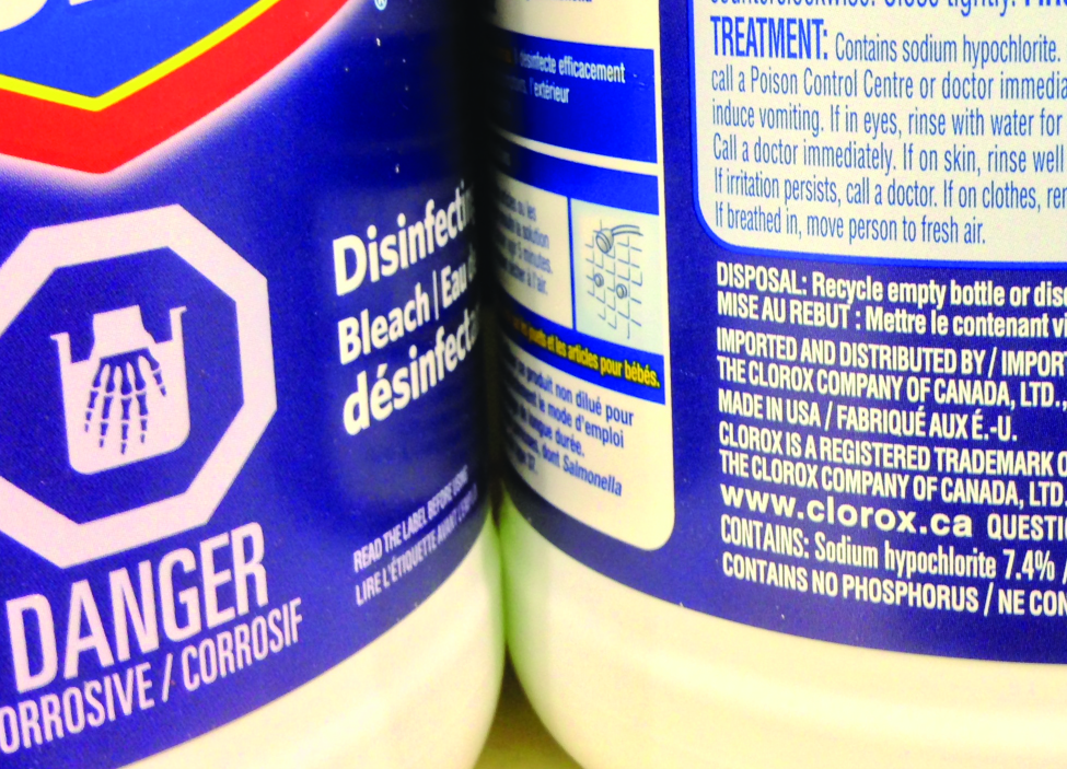The sides of two cylindrical containers are shown. Each container’s label is partially visible. The left container’s label reads “Bleach.” The right label contains more information about the product including the phrase, “Contains: Sodium hypochlorite 7.4 %.”