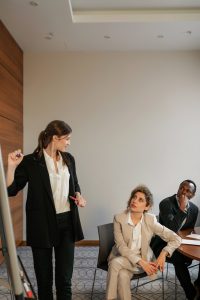 Woman presenting to seated people.