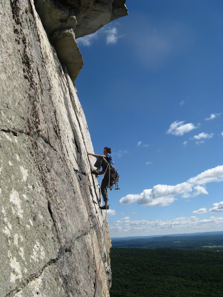 A man climbing a sheer rock cliff