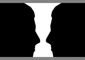 illustration of two people facing each other with white space in between is an optical illusion that can also look like a white vase