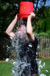 A person dumping a bucket of water over their head.