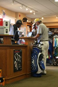 AJames Grimmett, right, purchases a slot in the July 24 men's league from Doug Thomas, pro-shop employee at Cheyenne Shadows Golf Club. Hundreds of community members visit the golf course each day.