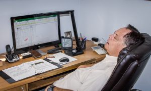 burned out guy sleeping in front of computer
