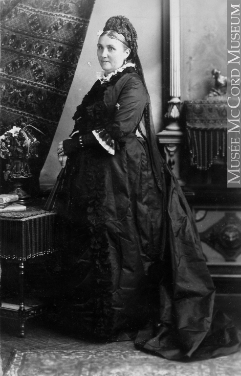 Annie Bannatyne as an older woman in formal, mourning attire.
