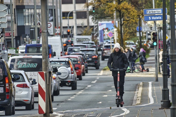 A man with E-scooter on a street