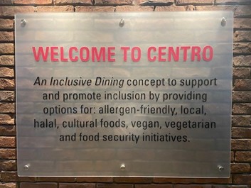 Hospitality Services Sign which reads welcome to centro in bright red and black text explaining their concept of "An Inclusive Dining".