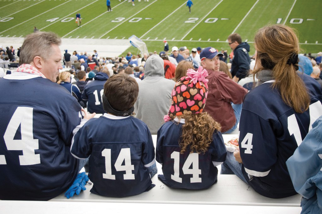 A family wearing matching jerseys at a football game.