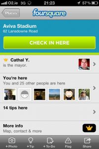A screenshot of Foursquare showing a button to check in at a location and profile images of others at the same location