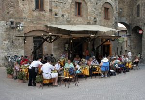 people sitting in an outdoor Tuscan cafe for lunch.