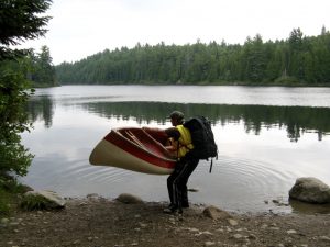 man lifting a canoe