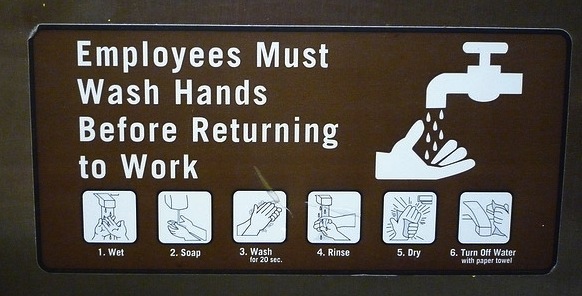 A sign saying, "Employees Must Wash Hands Before Returning to Work."