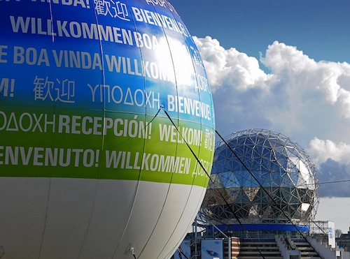 A large sign outside of science world with "welcome!" in many different languages.