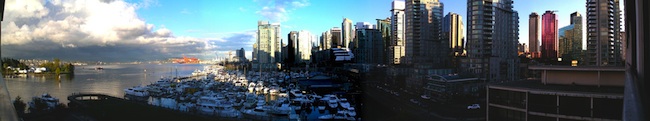 A harbour filled with boats in front of Vancouver's tall city buildings