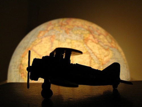 A toy plane in front of a globe.