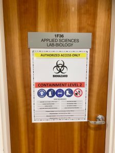 Classroom door with sign that says Authorized access only. Biohazard containment level 2.