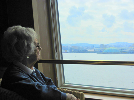 A woman with white hair, wrinkly skin, and glasses.