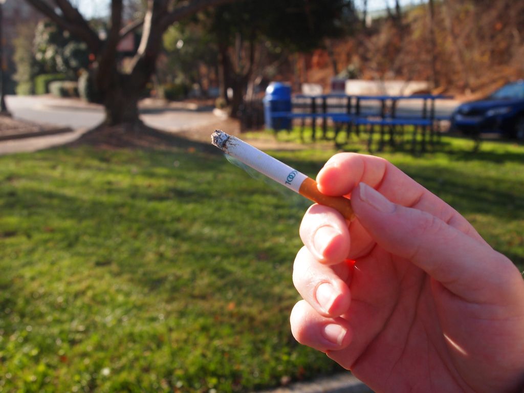 Hand holding burning cigarette