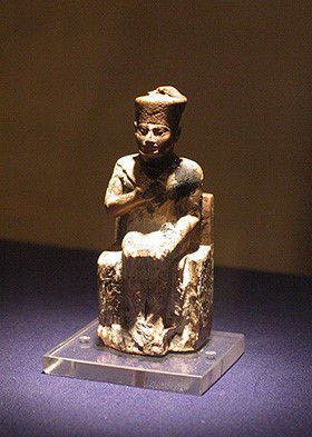 The figure is seated holding the symbols of a pharaoh's power