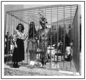 A black and white photograph of "The Couple in the Cage: A Guatinaui Odyssey"