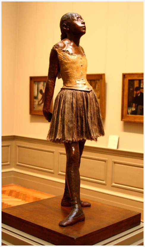 Brown stone little girl in a skirt on a pedestal