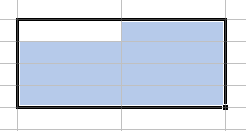Quelques cellules Excel sélectionnées formant un rectangle à bordure noire. Toutes les cellules sélectionnées sont bleues sauf celle en haut à gauche qui est blanche.