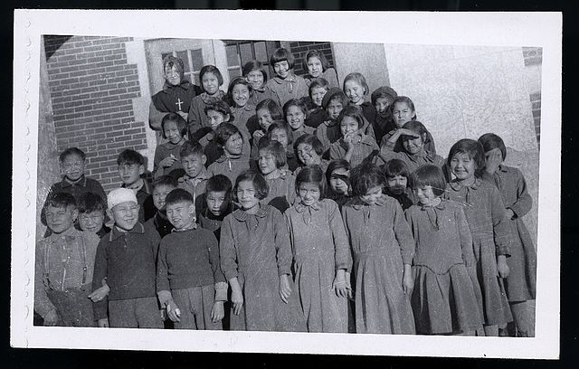 A black and white photograph of students at residential school.