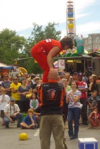 An acrobat performs in the street.