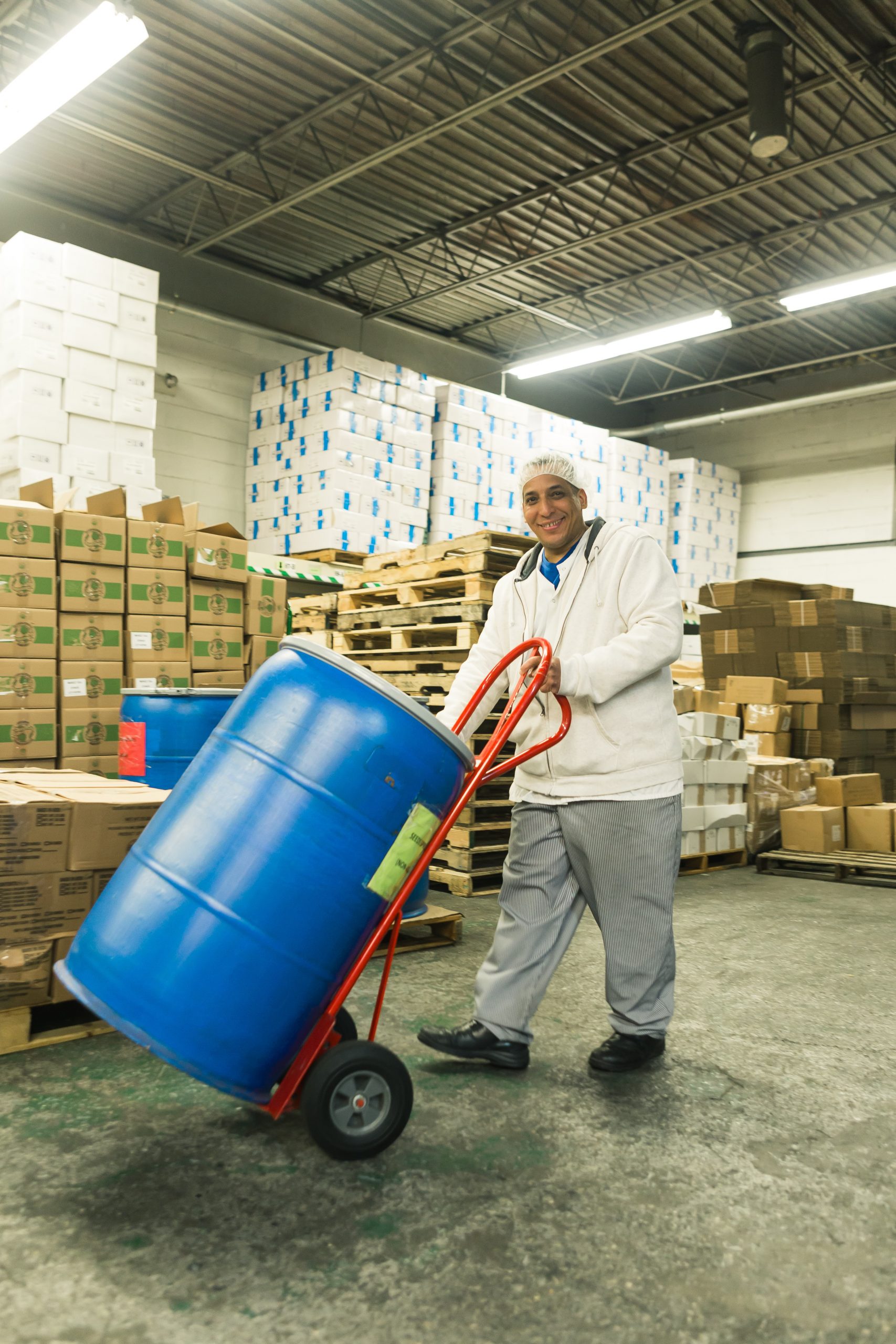 Warehouse worker moving a barrel of goods.