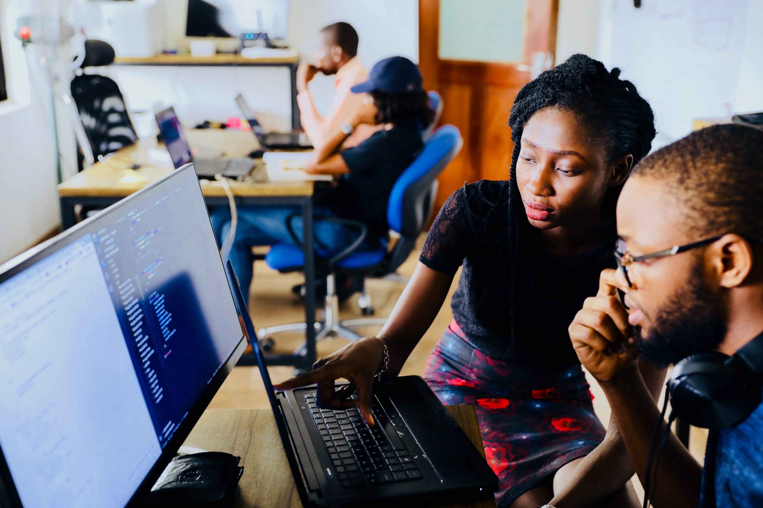 A woman sitting with a man looking at a computer screen