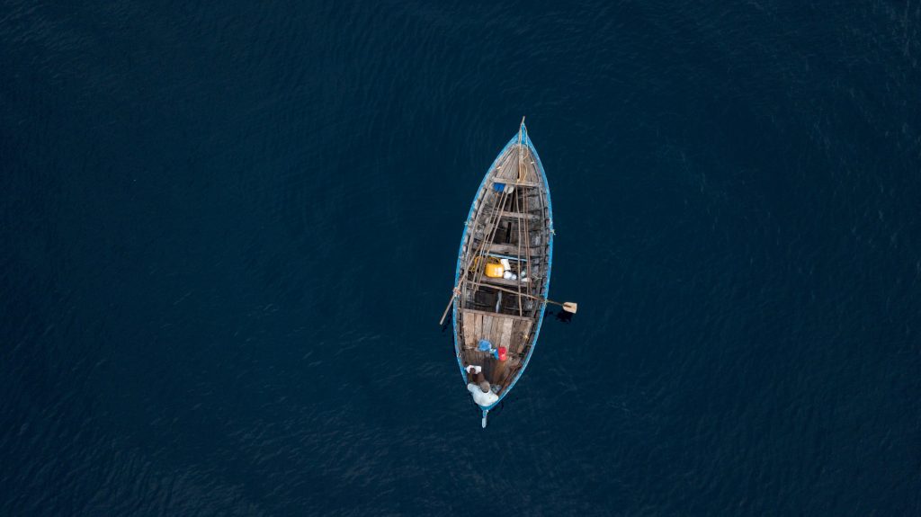 An aerial view of a boat on open water depicting navigation.