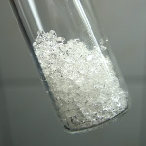 Approximately two grams of phenol in glass vial.