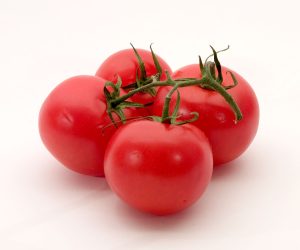 four bright red tomatoes on a vine