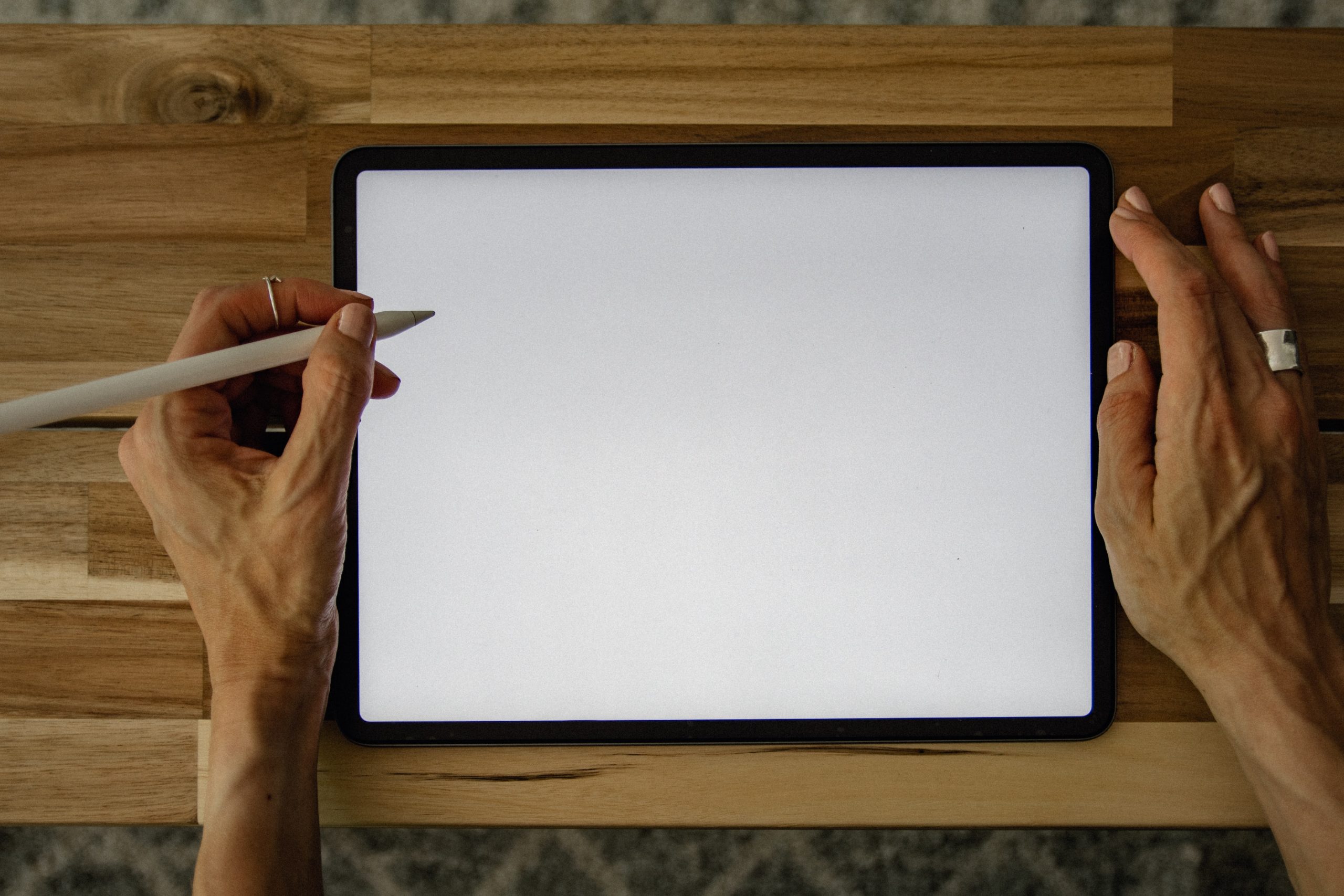 a person looks at a blank tablet with a pen poised to write