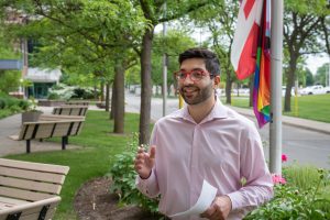 Joseph Pazzano: Director of Equity, Diversity and Inclusion outside in front of Pride flag.