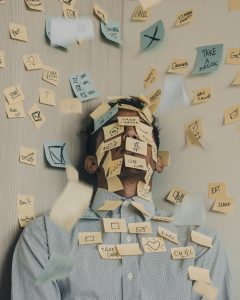 Man in corner with sticky notes all over him and the wall