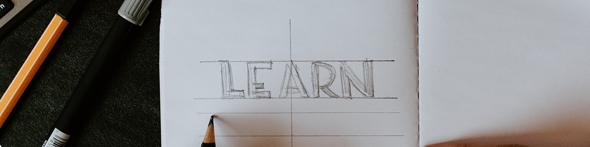 The word "Learn" written in block letters from pencil with linear line guides