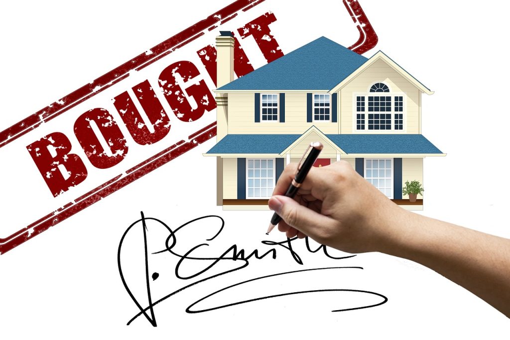 Image showing a house in the background with a stamp that says "BOUGHT" and a hand holding a pen finishing off a signature.