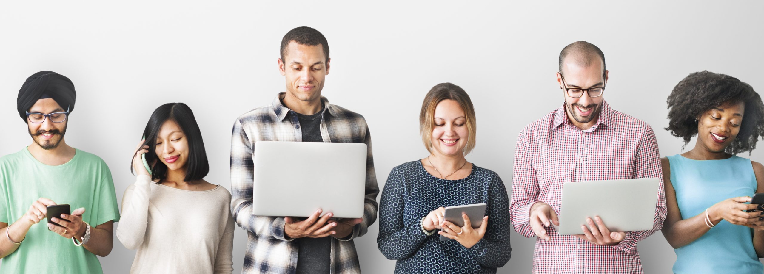 Group of diverse people using a variety of digital devices.