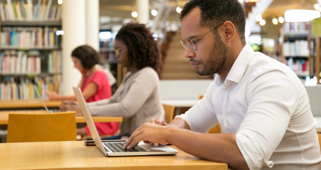 People sitting at desks and using laptops. 