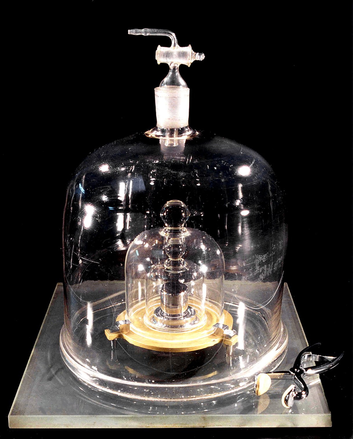 a metal cylinder placed in a tightly secured glass bell jar.