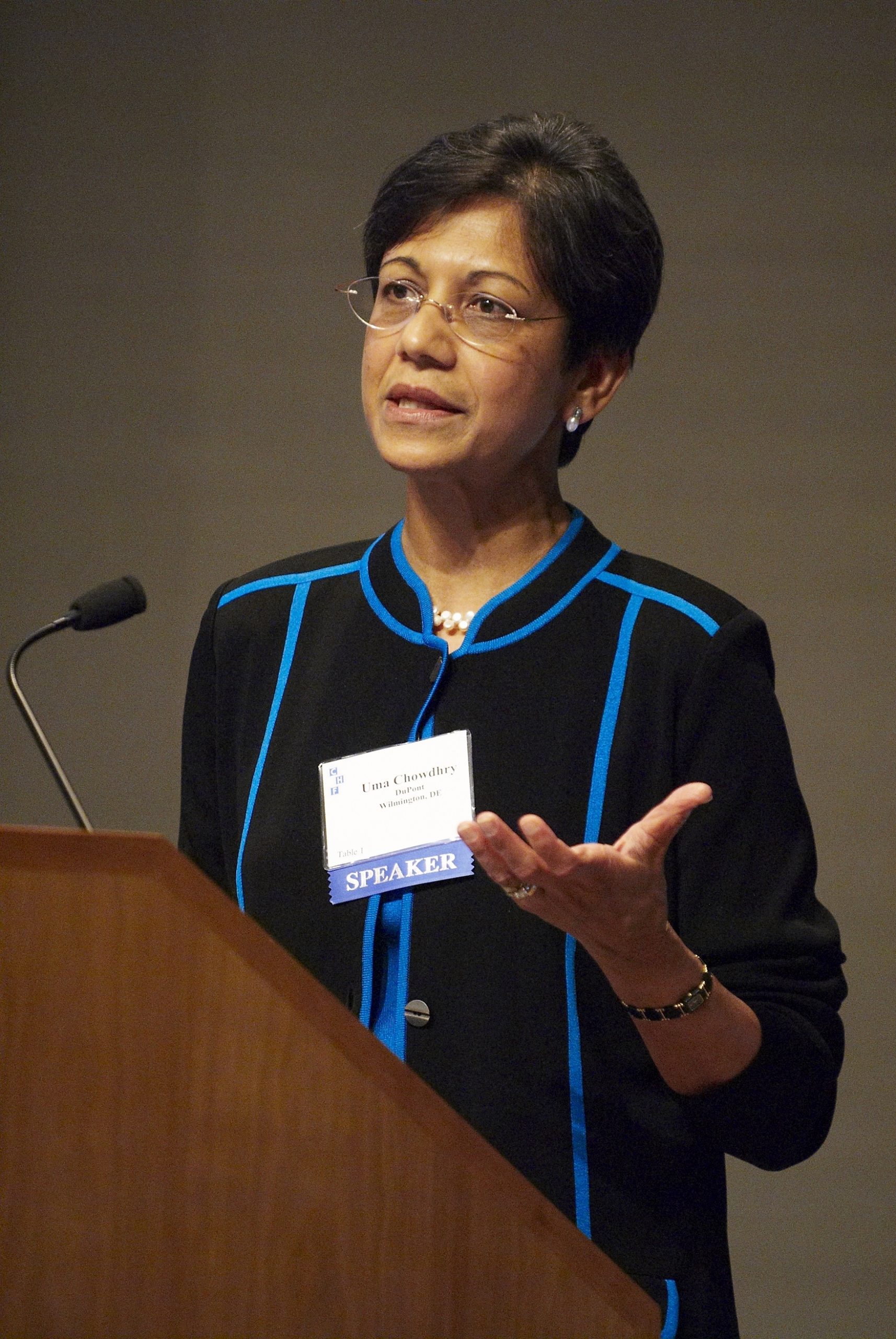 Photograph of Dr. Uma Chowdhry lecturing at a podium.
