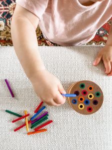 container with different sized holes and individual sticks that fit into those holes.